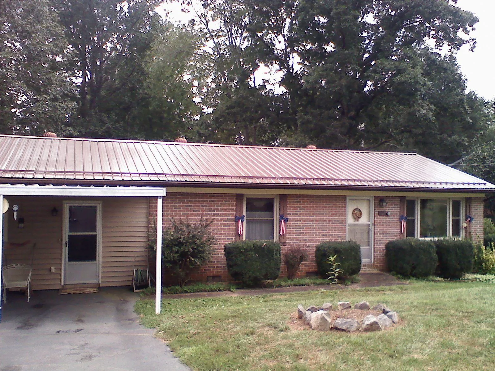 Bronze metal roof and carport on a brick ranch home — Roof Repair work by our crew in Thompson